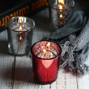 Close-up of electroplated glass candle holders with lit candles for cozy home decor.