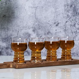 Juego de cuatro vasos de cata de cerveza artesanal en una tabla de madera rústica