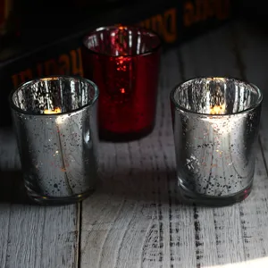 Detailed view of electroplated mercury glass candle holders in silver and red now.