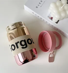 Primo piano di una borraccia in vetro sfumato con custodia Gorgeous e tappo rosa coordinato.