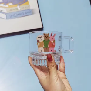 Clear glass coffee mug detail featuring cute cartoon animal print and ribbed bottom design for daily use.
