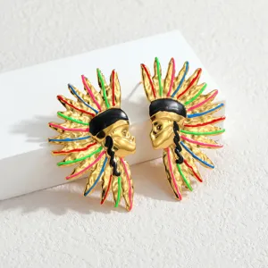 Macro-opname van goudkleurige Indianenhoofd oorbellen met kleurrijke emaille details