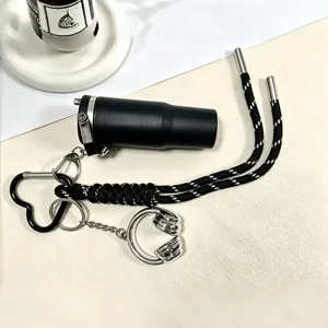 Cute braided keychain charm with mini water bottle and headphone pendant for stylish bags.
