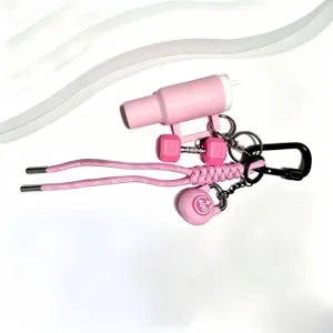 Mini ensemble de porte-clés de fitness rose avec gourde, haltère et kettlebell tendance.