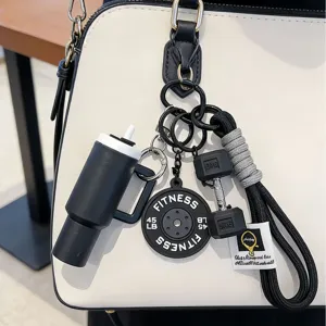 Close-up of fitness keychain with mini water bottle and dumbbell charms on a bag