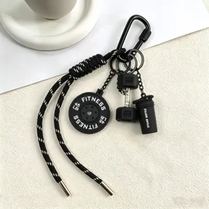 Detailed close-up view of the black fitness keychain featuring miniature dumbbell and shaker.