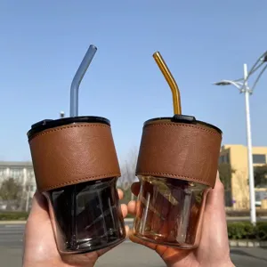 Vista dettagliata di tazze da caffè in vetro resistente al calore con custodia in pelle
