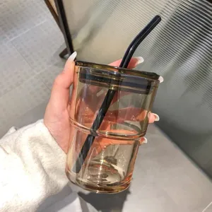 Vista dettagliata di un bicchiere ambrato resistente al calore con coperchio e cannuccia nera