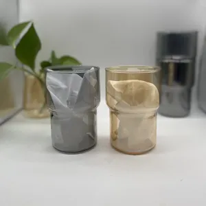 Dettaglio di bicchieri impilabili resistenti al calore in grigio fumo e oro ambrato