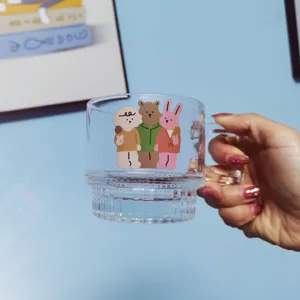Clear glass coffee mug with handle and cute cartoon animal print, modern design for daily use.