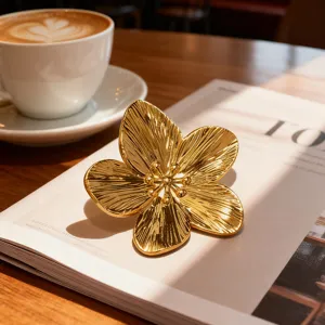 Primo piano di una spilla a fiore dorato 3D con petali testurizzati