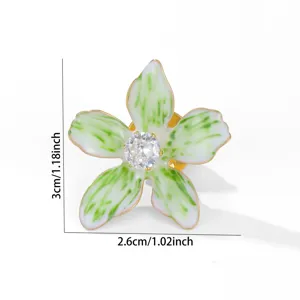 Detailansicht der grün-weißen Emaille-Blumenbrosche mit zentralem Kristall