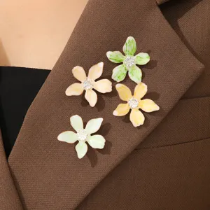 Detailansicht von vier farbenfrohen Emaille-Blumenbroschen an einem braunen Revers
