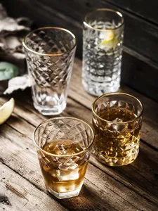 Macro detail of retro embossed glass cups with elegant gold rims on wooden table