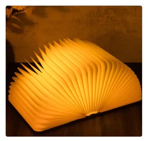 Dettaglio di una lampada a libro pieghevole a LED che emette luce calda arancione