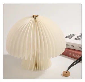 Detailaufnahme einer kreativen faltbaren Pilz-Nachtlampe mit Akkordeon-Schirm und Holzoberseite.