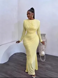 Detailed view of elegant lemon yellow long sleeve ruched bodycon dress in modern indoor setting.