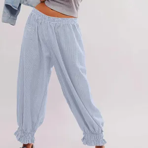 Close-up detail of casual striped pants featuring high elastic waist and ruffled ankle cuffs.