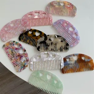Detailed view of colorful acetate hair combs featuring delicate hollow heart patterns