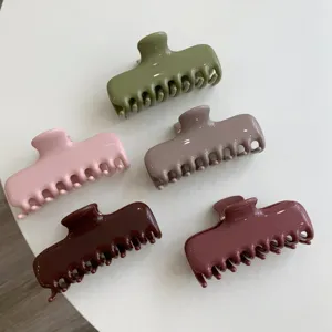Vista detallada de pinzas para el cabello de plástico brillante de alta calidad en tonos tierra