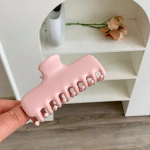 Primer plano de una pinza para el cabello rosa brillante con diseño de doble resorte.