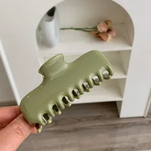 Detalle en primer plano de una pinza para el cabello verde oliva para un estilo diario elegante.