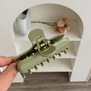 Detalle de una pinza para el pelo minimalista de PC verde salvia con doble resorte