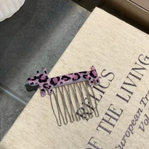 Detailed macro view of a purple leopard print dog hair comb made from premium acetate.