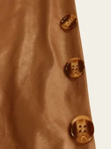 Detaillierte Nahaufnahme von glänzendem braunem Satinstoff und Schildpattknöpfen am Kleid