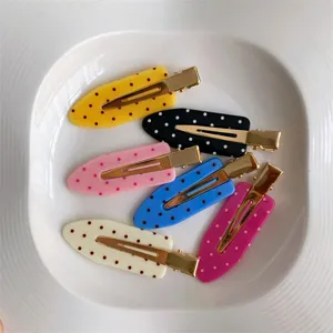 Close-up showing a collection of colorful polka dot seamless hair clips in macaron colors