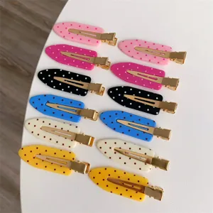 Close-up detail showing colorful polka dot hair clips in various vibrant macaron shades