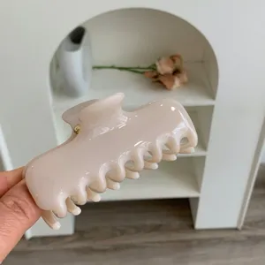 Primer plano de una pinza para el cabello de PC color crema brillante y dientes lisos