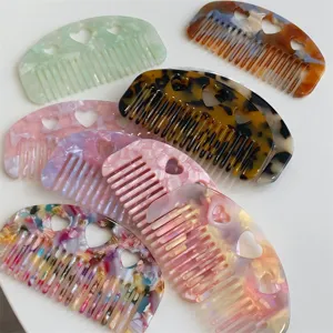 Elegant heart-shaped acetate hair combs in various marble colors for stylish portable use.