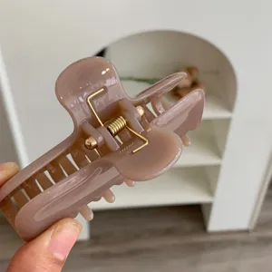 Primer plano de una pinza para el pelo minimalista en PC rosa viejo con doble resorte.