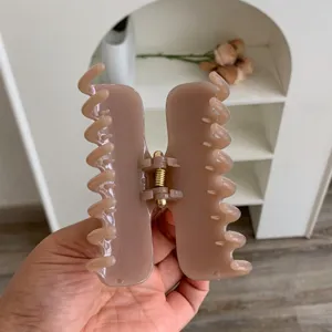 Primer plano de una pinza para el cabello malva con doble resorte estilo minimalista