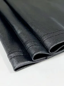 Makroaufnahme eines hochwertigen schwarzen Kunstlederkleides mit feiner Textur und Nähten