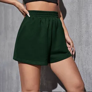 Close-up of high-waist dark green loose athletic shorts with elastic waistband.