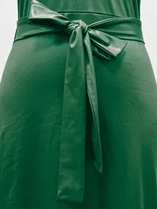 Detailansicht der grünen Kleid-Taille mit Schleife und Kunstledertextur