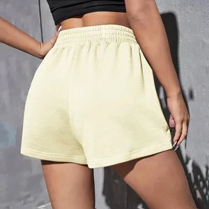 Back view of women's loose athletic shorts with elastic high waist in pale yellow.
