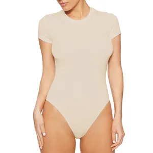 Close-up view of the beige short-sleeve bodysuit, showing the fitted cut and soft fabric.