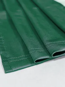 Detailaufnahme von dunkelgrünem Kunstleder-Kleidstoff mit sauberer Saumnaht