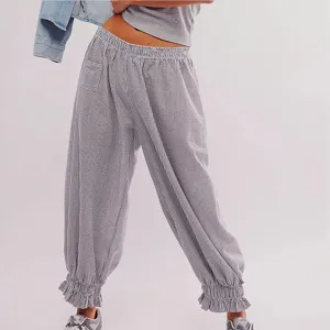 Detailed view of women's striped casual pants featuring ruffled hem and elastic high waist.