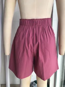 Detail view of women high waist elastic shorts in dark pink, loose wide leg style.