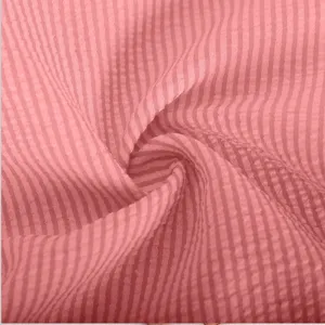 Close up of pink striped seersucker fabric texture detail, lightweight and breathable material.