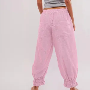 Detail shot of casual pink striped pants featuring ruffle cuffs, elastic waist, and pockets.