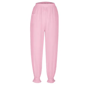 Detailed view of pink pleated trousers featuring elastic waistband and cute ruffled cuffs.