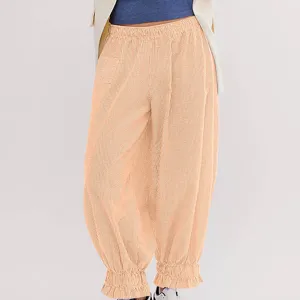 Detail view of orange textured wide-leg pants with elastic ruffle cuffs and comfortable waist.