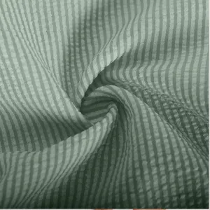 Close-up detail of light green striped seersucker fabric showing texture and soft material.