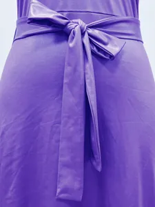Makroaufnahme der stilvollen Taillenschleife an einem lila ärmellosen Kleid aus Kunstleder