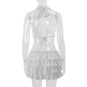 Détails de dos du haut dos-nu blanc à halter et de la mini-jupe évasée à volants multiples.